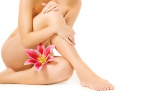 Female legs with pink lily isolated on white background